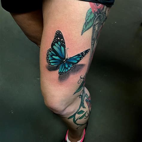 butterfly tattoo with flowers around it|realistic butterfly tattoo.